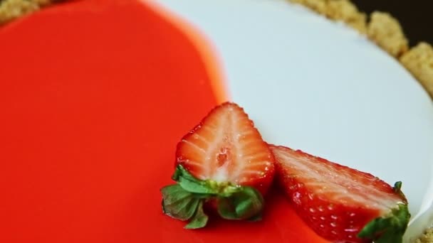 Macro view panorama abajo en pastel de queso glaseado con fresas en rodajas — Vídeo de stock