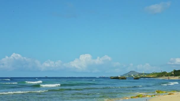 White fluffy clouds above blue ocean with waves and golden sand beach — ストック動画