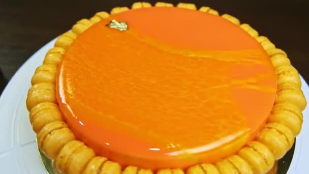Top view on whole round cheesecake decorated with mini macaroons rotates around — Stock video
