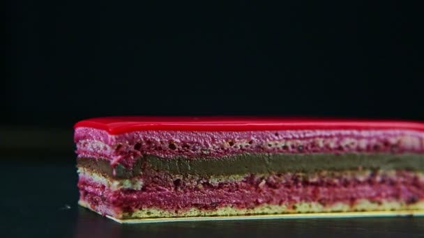 Closeup focus out from one portion of pink glazed chocolate and berry layered cake — Stock Video