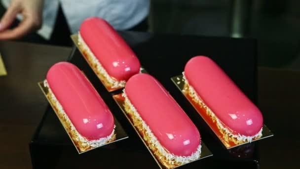 Confeiteiro serve cinco porções de sobremesas de vidro rosa com raspas de coco — Vídeo de Stock