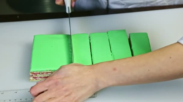 Closeup πρόσωπο κοπεί σε μερίδες από μαχαίρι πράσινο γλασαρισμένο κέικ με γέμιση φρούτων — Αρχείο Βίντεο