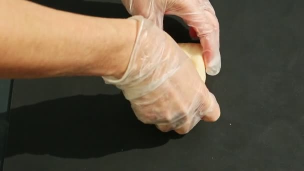 Pohled shora na ženské ruce vzít kostku bílého marcipánu a hnětení s oranžovou barvou — Stock video