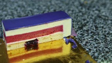 Kırmızı jöleli menekşe kaplı kremalı pastaya yakın çekim panoraması.