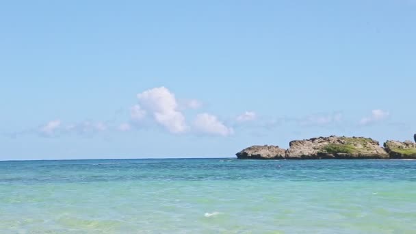 Gros plan panorama sur les vagues blanches se brisent à grande île rocheuse dans l'océan bleu — Video