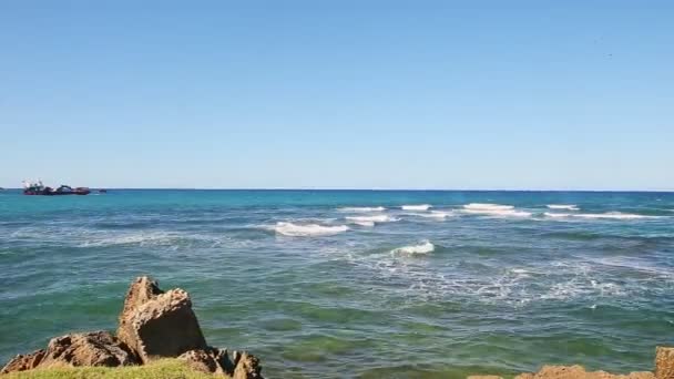 Langzaam panorama op witte golven in eindeloze oceaan breken op rotsachtige kust — Stockvideo