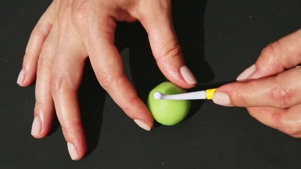 Vista superior de las manos de la mujer haciendo caramelos en forma de manzana de la masa de mazapán verde — Vídeo de stock