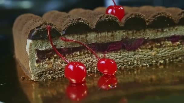 Closeup red double cherry against half of chocolate cake with cherry interlayer — Stock Video
