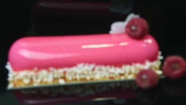 Nahaufnahme Fokus in und aus rosa glasiertem Dessert mit Kokos und Himbeeren — Stockvideo