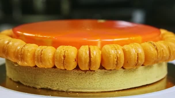 Läckra hela runda orange glaserade tårta med mini makaroner roterar runt — Stockvideo