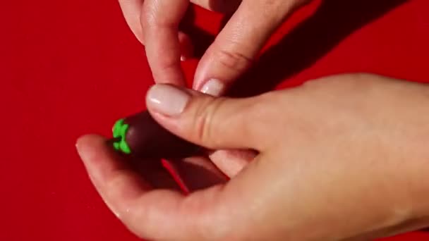 Vue de dessus sur les mains humaines mettre des bonbons en forme d'aubergine massepain dans le stand brun — Video