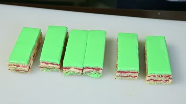 Кондитерские изделия, вырезанные на порциях ножом зеленый глазурованный торт — стоковое видео