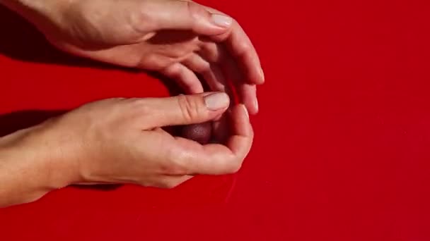 Вид сверху на женские руки выкатывает маленький кусочек баклажана марципана массы — стоковое видео