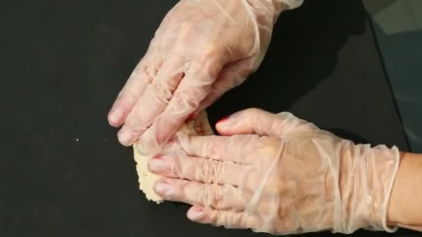 Vista superior em mãos femininas amassar grande pedaço de maçapão branco com corante laranja — Vídeo de Stock