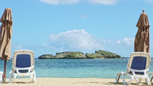 Closeup praia de areia branca vazia com longas cadeiras de praia e guarda-chuvas fechados — Vídeo de Stock