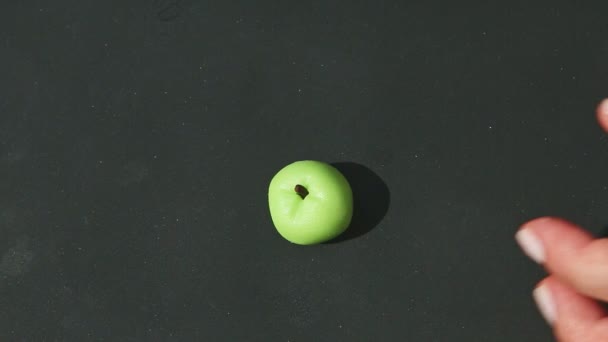 Top view on hands take green marzipan apple shape candy and brown paper stand — Stock Video