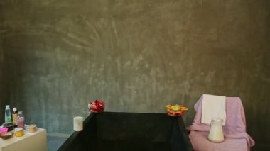 Ekoseye sarılı güzel sarışın kız büyük siyah bir banyoyla modern banyoya giriyor.