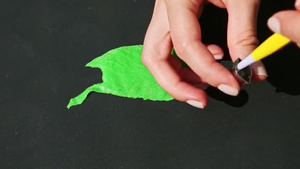緑色のマジパンの塊から小さな葉の形を作る女性の手の上からの眺め — ストック動画