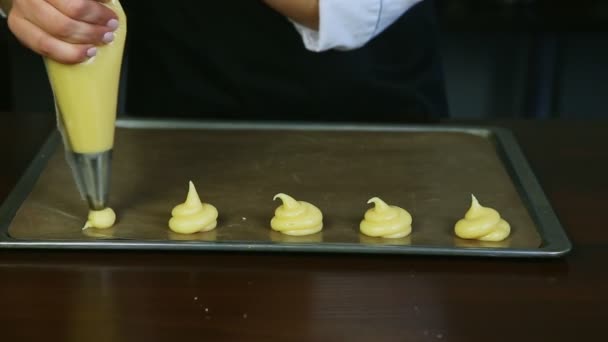 Primer plano de las manos de la mujer forman pequeñas galletas formas por bolsa de pastelería en paleta de metal para hornear — Vídeo de stock