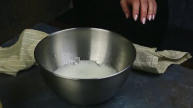 Yakın plan ahır çırpılmış yumurta beyazı derin metal kasede çırpılmış.