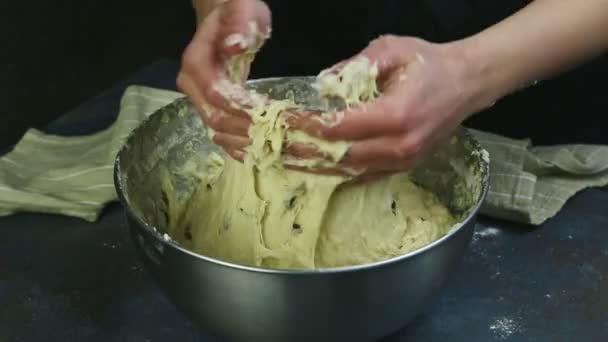 Primo piano donna a mano impastare pasta di lievito morbido con uvetta in ciotola di metallo profondo — Video Stock