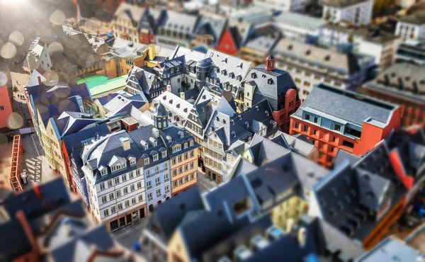 Tilt shift blur effect. Abstract cityscape with old architeture buildings. Frankfurt, Germany aerial view panorama with sunlight.