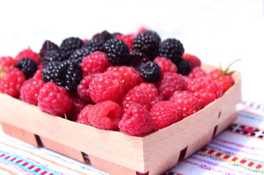 Siyah ve Kırmızı Ahududu ve arka plan üzerinde ahşap küçük kutuda 