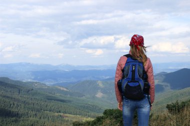Sırt çantası ayakta mountai üstünde olan kadın (fiyatı)