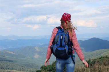 Sırt çantası ayakta mountai üstünde olan kadın (fiyatı)