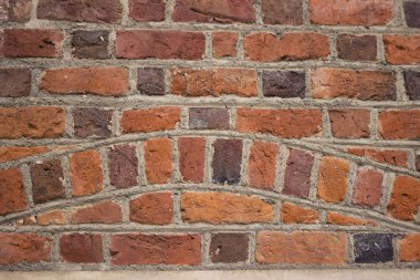 Arka plan, eski bir binanın parlak kırmızı tuğlalı duvarı. Tuğla desenli duvarcılık