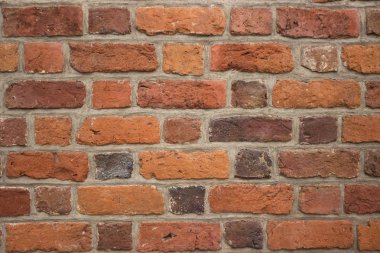 Arka plan, eski bir binanın parlak kırmızı tuğlalı duvarı. Tuğla desenli duvarcılık