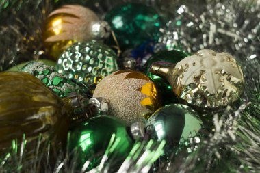 Yeni yılın sarı ve yeşil oyuncakları parlak bir çelengin üzerinde yatıyor. Fındık şeklinde eski oyuncaklar, kar taneleri, toplar. Yeni yıl ve Noel geçmişi, konsept