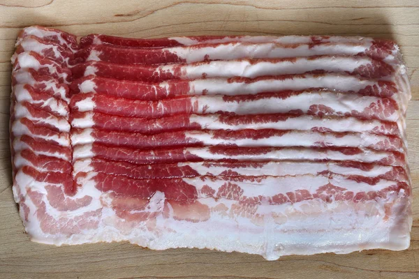Bacon slice on wooden cutting board — Stock Photo, Image