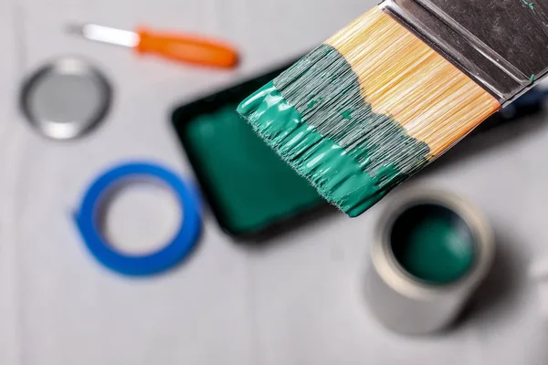 Hand with paint brush and green paint — Stock Photo, Image