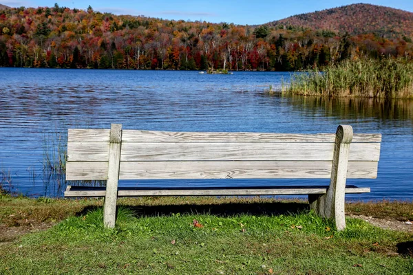 Empty seat bench near lake with autumn colors — Stock Photo, Image