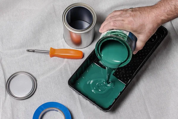 Hands pouring paint to paint try with  other tools on back — Stock Photo, Image