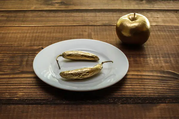 Золотой перец и яблоко на деревенском деревянном столе — стоковое фото