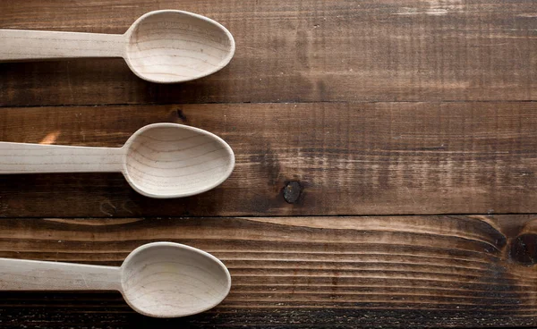 Tre cucchiai di legno vuoti sul piano del tavolo in legno — Foto Stock