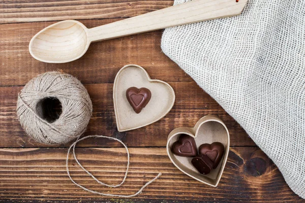 Mesa rústica com colher de madeira, cordão e corações — Fotografia de Stock