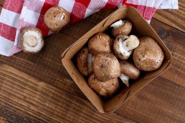 Tahta masadaki kağıt kutunun içinde mantar mantarı var.