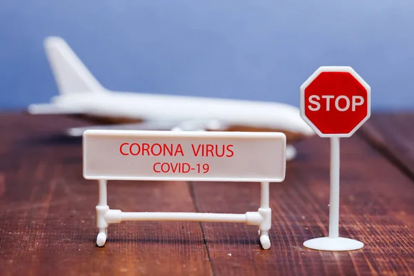 Corona virus sign on foreground with toy aeroplane in back — Stockfoto