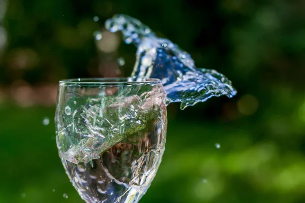 Ręczne Trzymanie Szkła Wodą Splash Zewnątrz Zielonymi Kolorami Tła — Zdjęcie stockowe