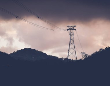Gökyüzünde fırtınalı bulutlar olan elektrik hattı