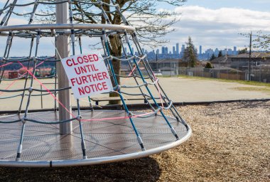 Vancouver, BC, Kanada, 10 Mayıs 2020, Vancouver, Burnaby 'de kapalı bir çocuk parkı COVID19 nedeniyle kapalı bir atlıkarınca, bir uyarı işareti ile UNTIL FURther NOTICE, bir ceza işareti ve turuncu güvenlik ağı ile kapalı