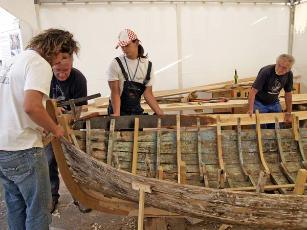 Brest, France - July 12, 2008: Croatian traditional shipbuilders are working on the restoration of an old wooden boat during the maritime festival — Stock Photo, Image