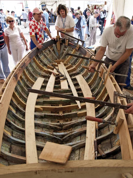 Brest, France - July 14, 2008: Croatian traditional shipbuilders are working on the restoration of an old wooden boat during the maritime festival — Stock Photo, Image