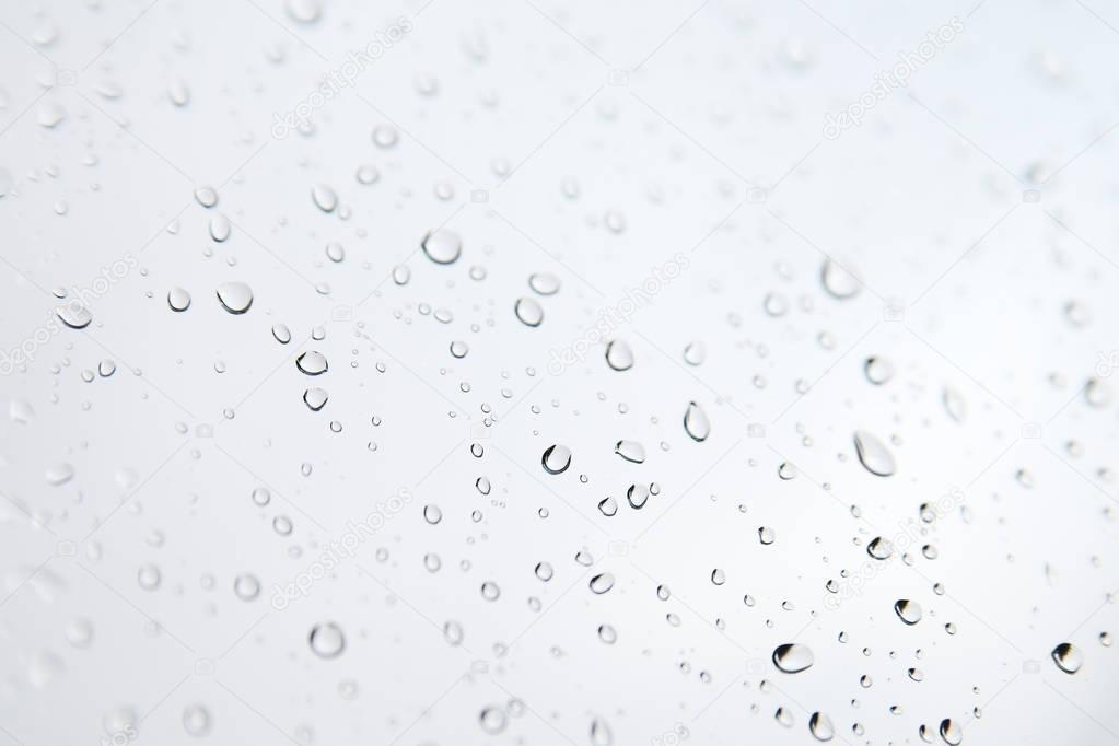 Monochrome blurred drops background.Rainy window.