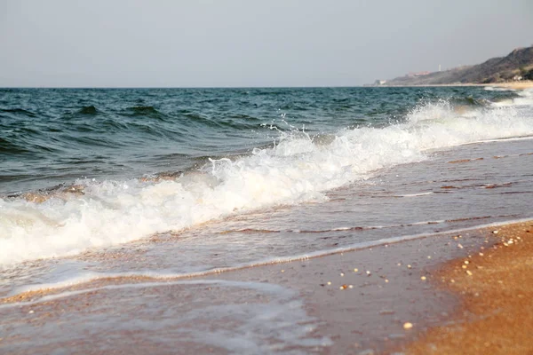 Fondo de mar tormentoso.Ondas y salpicaduras.Playa de arena . — Foto de Stock