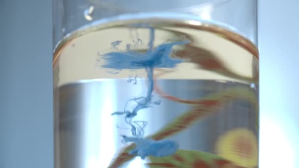 Blauwe verf inkt verspreid in glas Water — Stockvideo