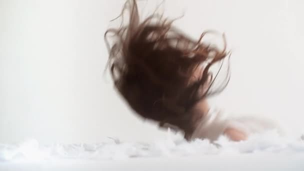 Woman falling on the bed with feathers — Stock Video